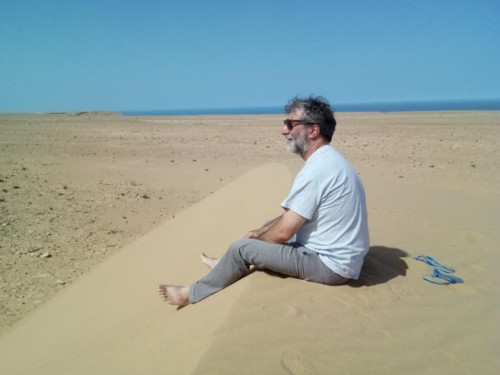 Alfonso assis sur le sable contemple le désert