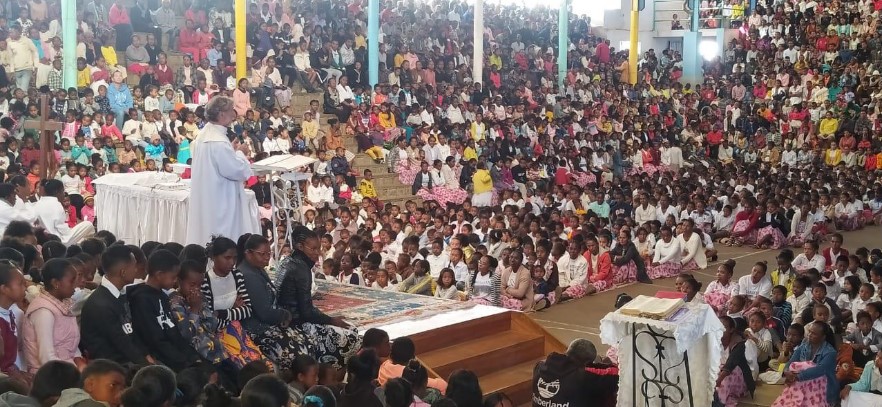 Alfonso préside une eucharistie dans une église malgache où plusieurs centaines d'enfants sont assis tout autour de l'autel, sur des gradins