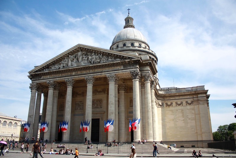 la façade du Panthéon avec des drapeaux tricolores accrochées aux piliers de la façade