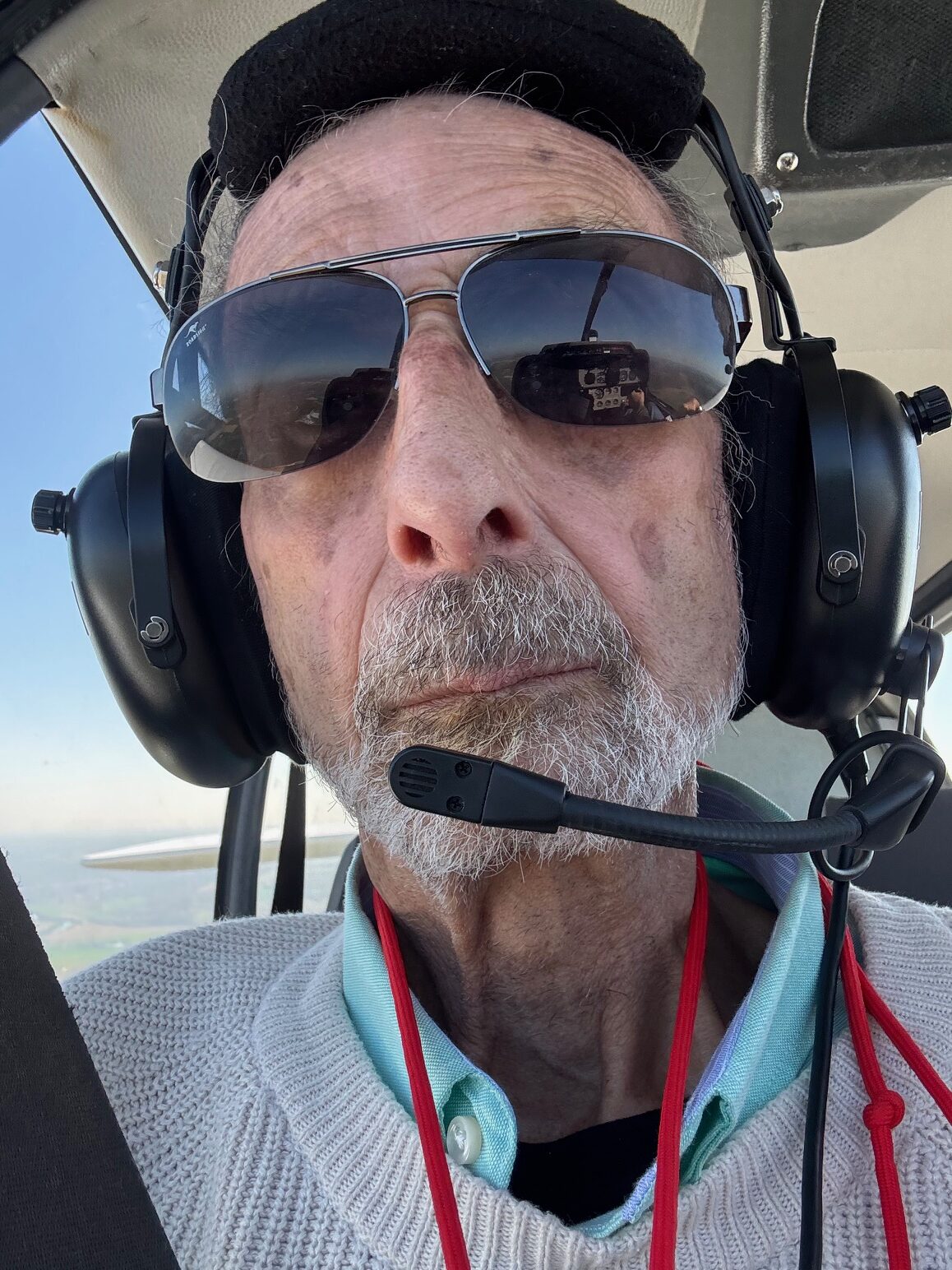 Yves Chalvet à la place du copilote, casque sur les oreilles et micro devant la bouche pour communiquer avec le pilote