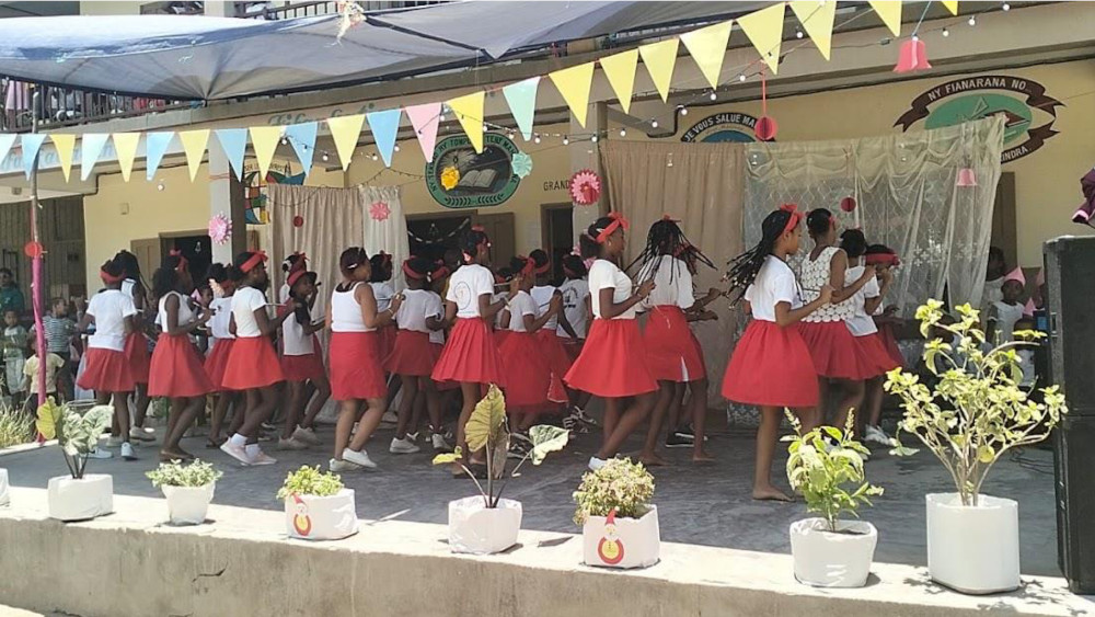des enfants dansent sur le podium de l'école durant la fête